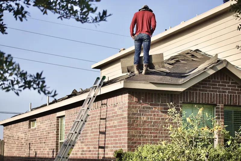 Professional roofer working on a residential roof in Fowers